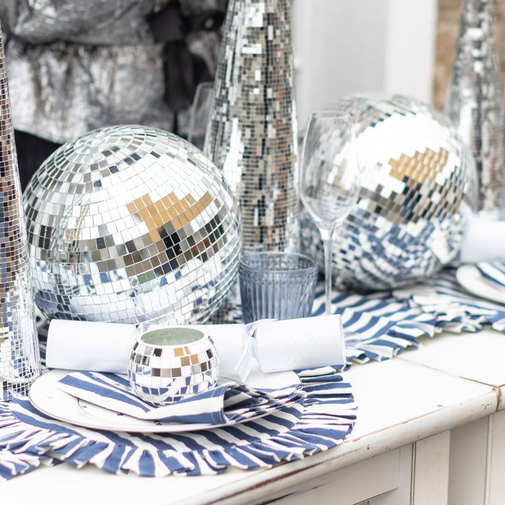 LNH Edit Iris blue stripe cotton napkins styled on a festive tablescape with disco ball decorations and silver accents.