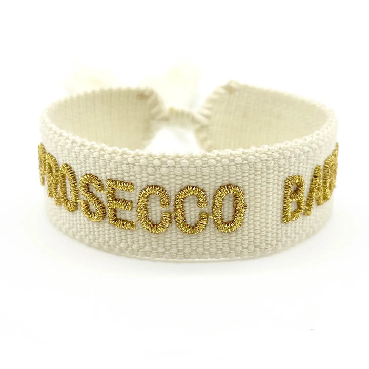 Prosecco Baby bracelet in beige with gold embroidered lettering by LNH Edit.