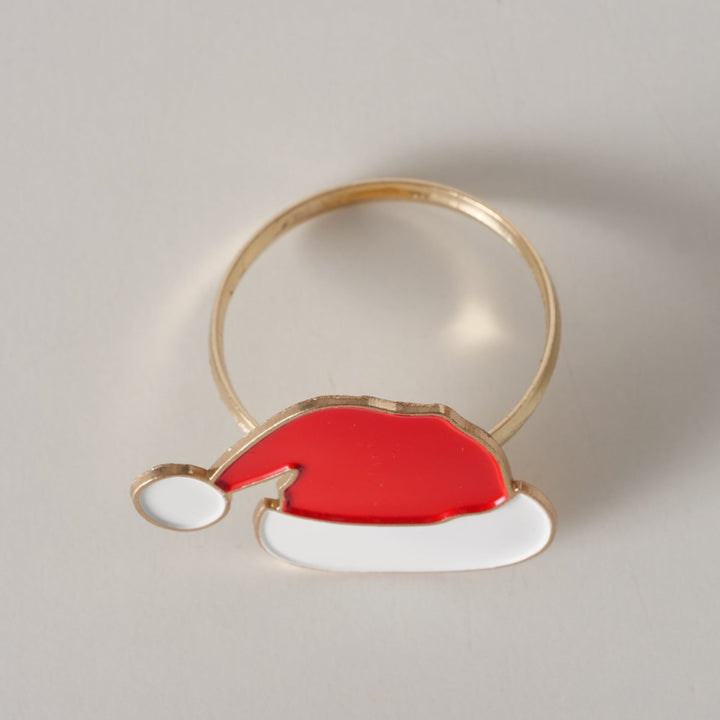 Close-up of handcrafted Santa hat napkin ring with gold base and enamel detail.
