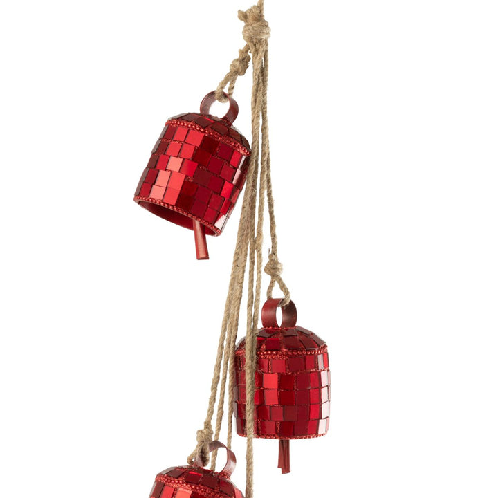 Red mirrored iron hanging bells styled on a wall for festive décor.