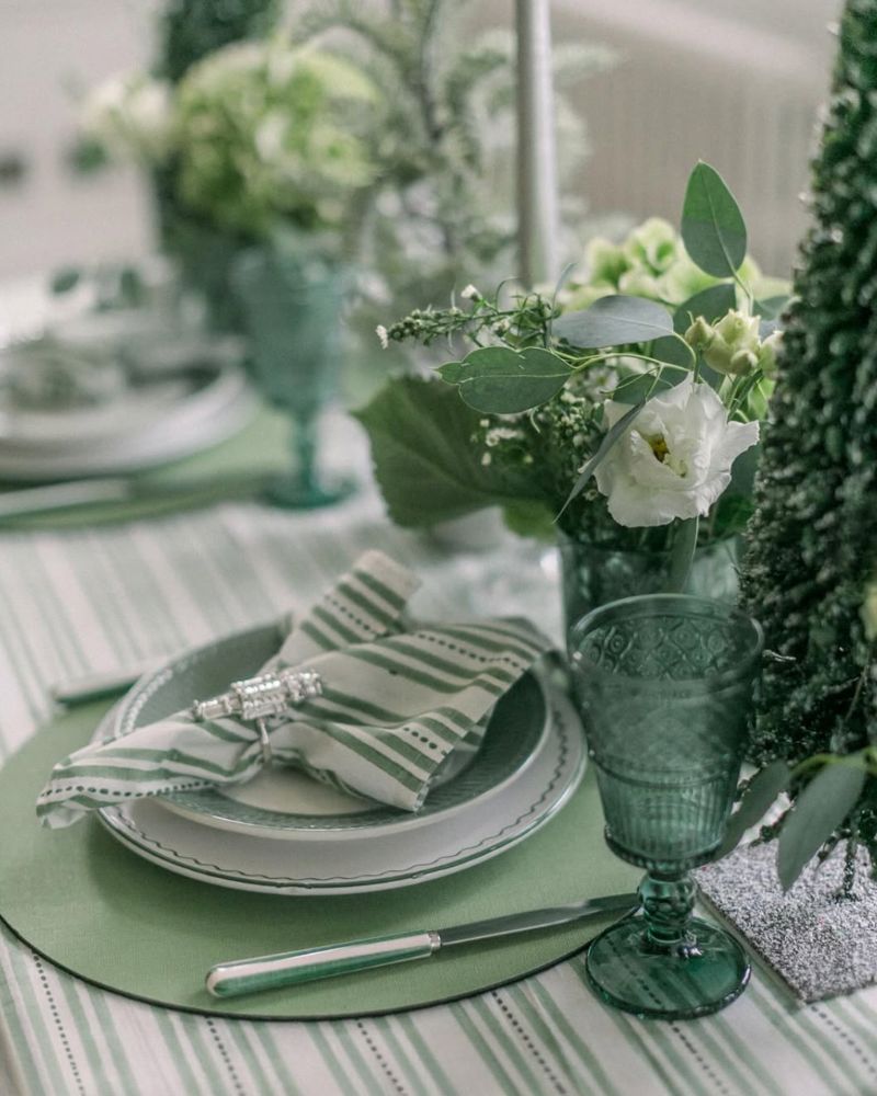 Elegant green Christmas tablescape with striped napkins, glassware, and festive greenery – LNH Edit