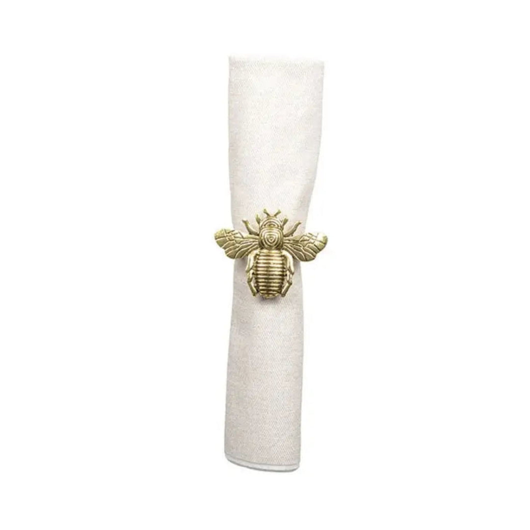 LNH Edit gold bee napkin ring securing cotton napkin, set of four brass napkin rings styled on elegant festive table setting.
