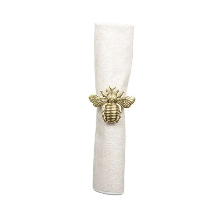 LNH Edit gold bee napkin ring securing cotton napkin, set of four brass napkin rings styled on elegant festive table setting.