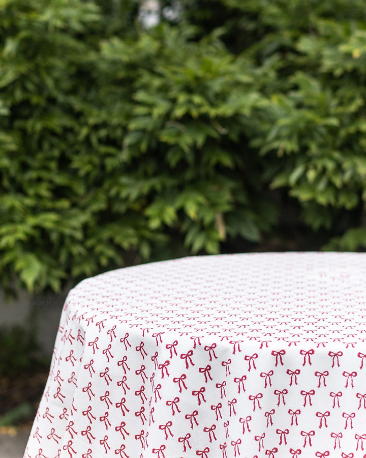 Christmas bow block print detail on cotton round tablecloth, handmade by artisans in India.