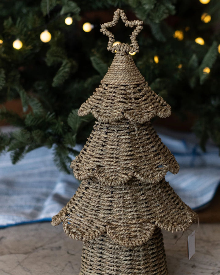 Natural rattan Christmas tree with star topper styled under a Christmas tree with fairy lights.