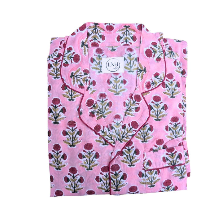 Pink floral long pyjama set with button-down top and matching trousers folded neatly on a white background.