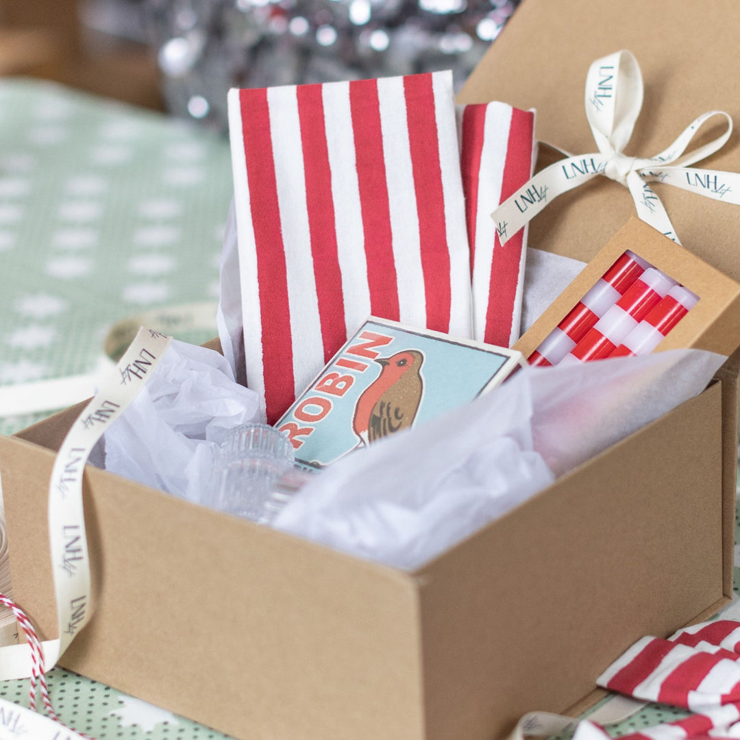 Festive red-and-white napkin and candle gift set from LNH Edit, styled for Christmas hosting.
