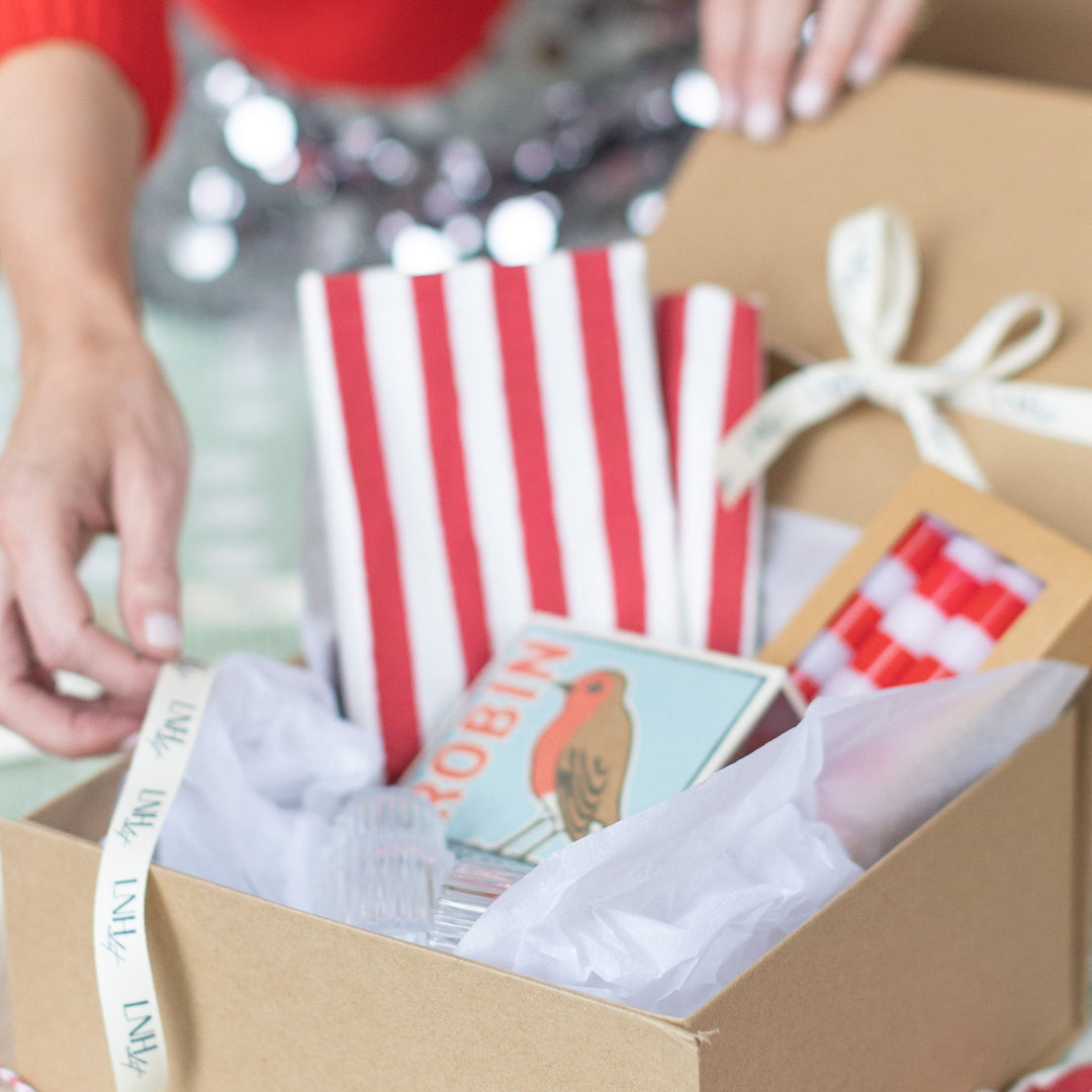 Unboxing the LNH Edit Holiday Hostess Gift Box featuring striped napkins and festive details.
