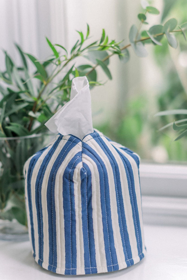 LNH Edit Iris blue and white striped cotton tissue box cover styled by a window with green foliage, handcrafted and block printed in India.