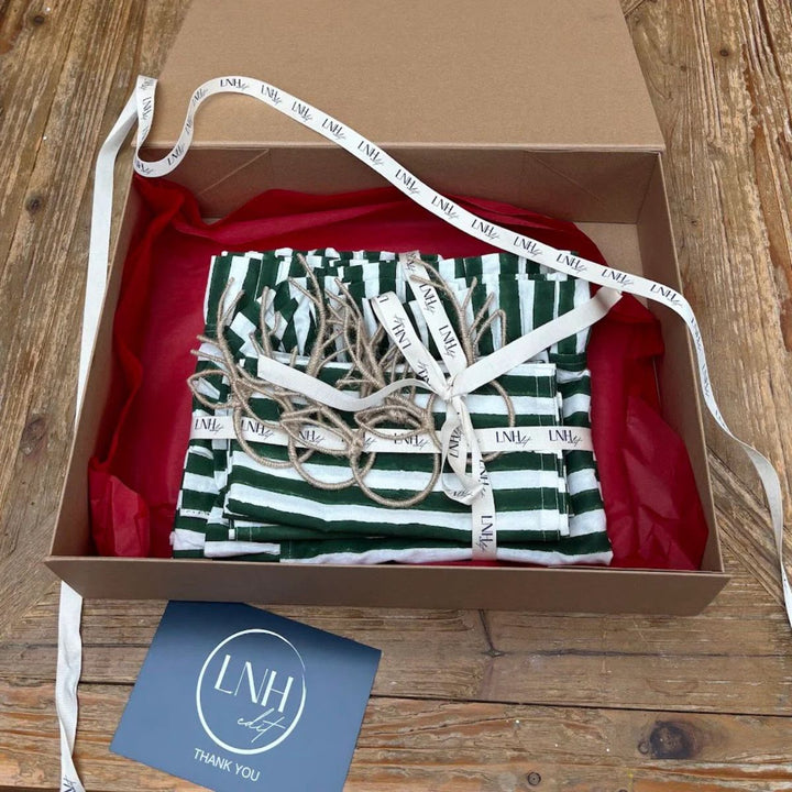 Ivy Hosting Gift Box with green striped napkins, ruffle table runner and reindeer napkin rings in LNH Edit packaging.