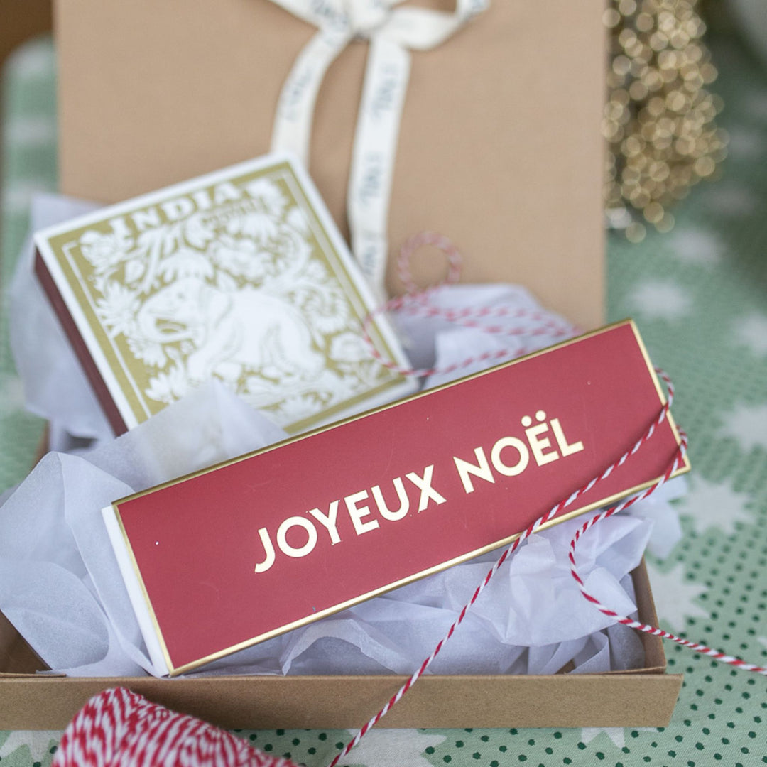 LNH Edit Joyeux Noël Gift Box with gold matchbox and red currant incense, wrapped in festive ribbon.