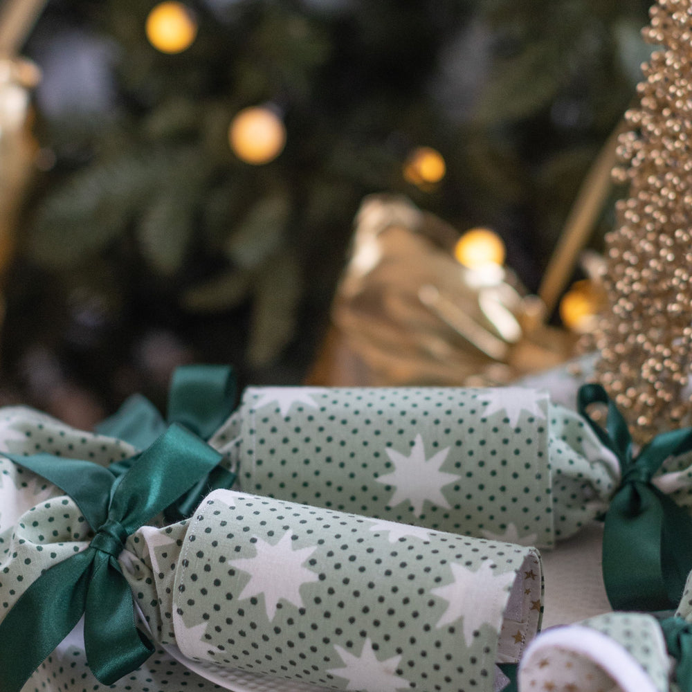 Close-up of reusable Mistletoe Green Christmas cracker with satin ribbon and star lining.