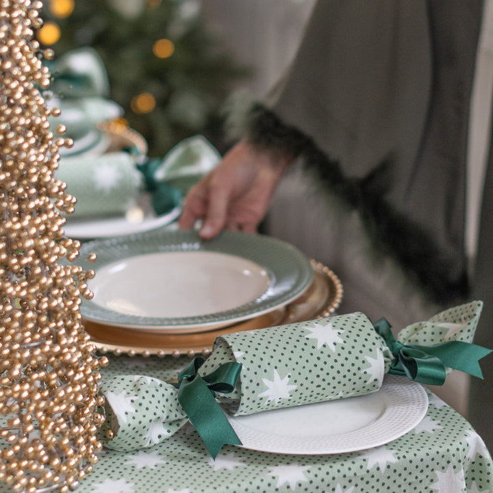 Laura styling festive table with green reusable Christmas crackers and gold décor by LNH Edit.