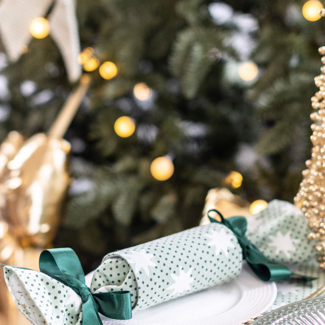 Close-up of reusable Mistletoe Green Christmas cracker with satin ribbon and star lining.