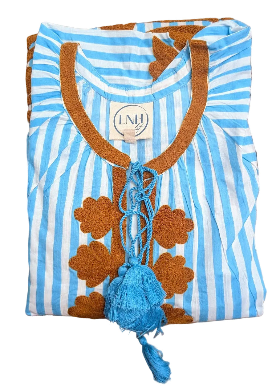 Blue and white striped dress with brown embroidery folded neatly