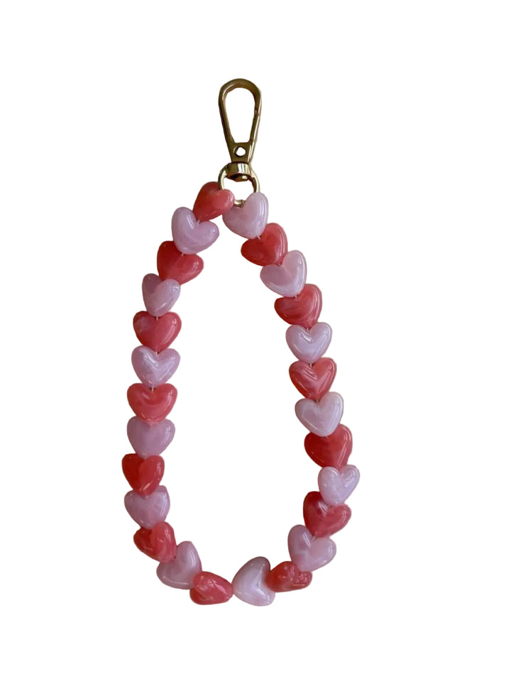 Heart-shaped bead keychain on a beige surface