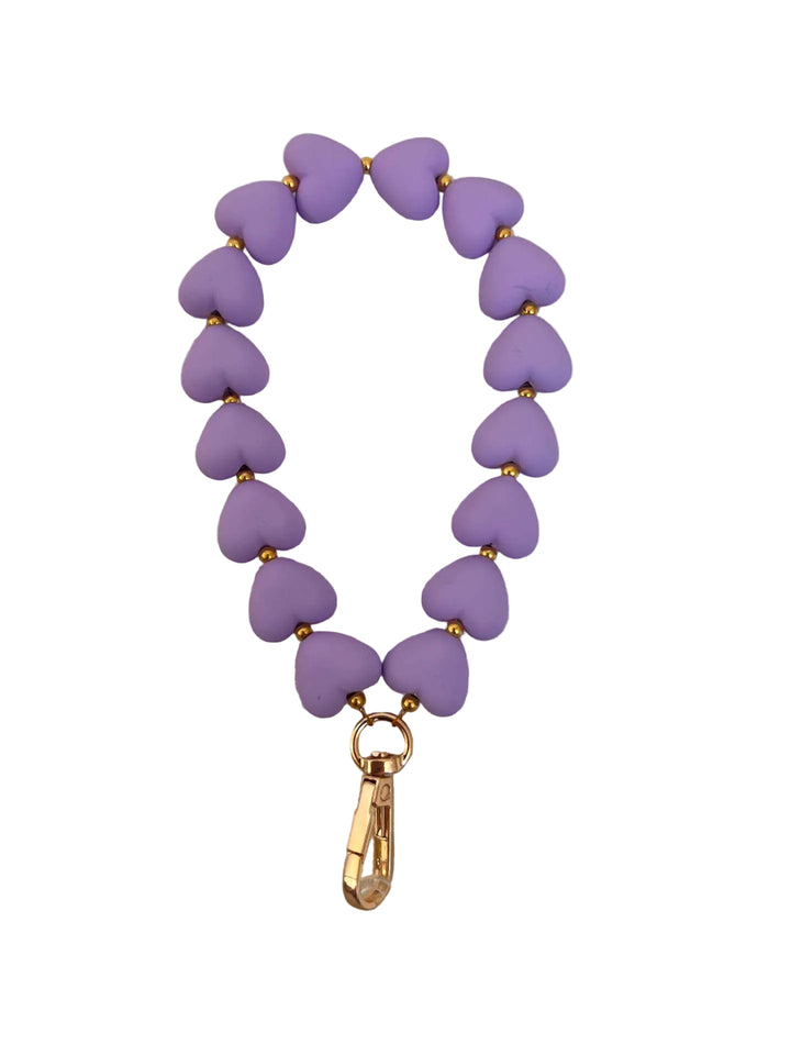 Purple heart-shaped beaded bracelet with a gold clasp on a light gray background