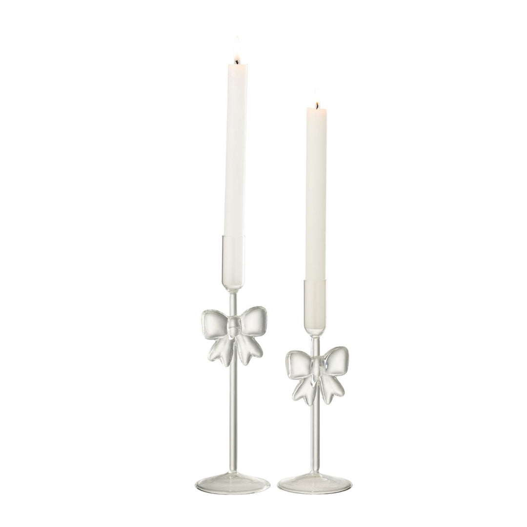 Glass candle holders with bows styled with lit taper candles, elegant Christmas table styling.