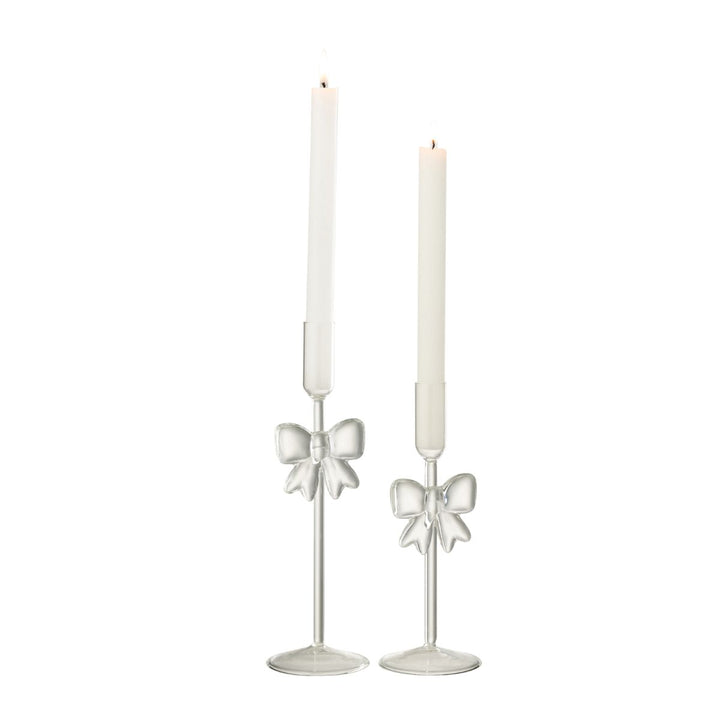 Glass candle holders with bows styled with lit taper candles, elegant Christmas table styling.