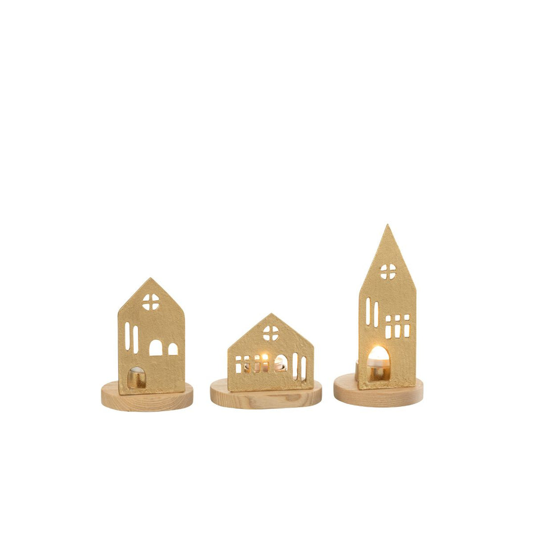 Gold house tealight holders glowing with candlelight.