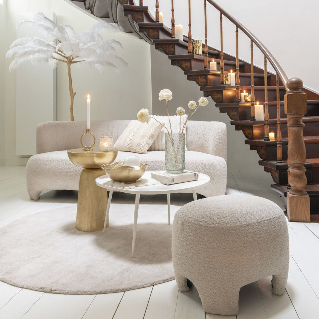 Gold ring candleholder styled in a modern neutral living room with candles and sculptural décor.