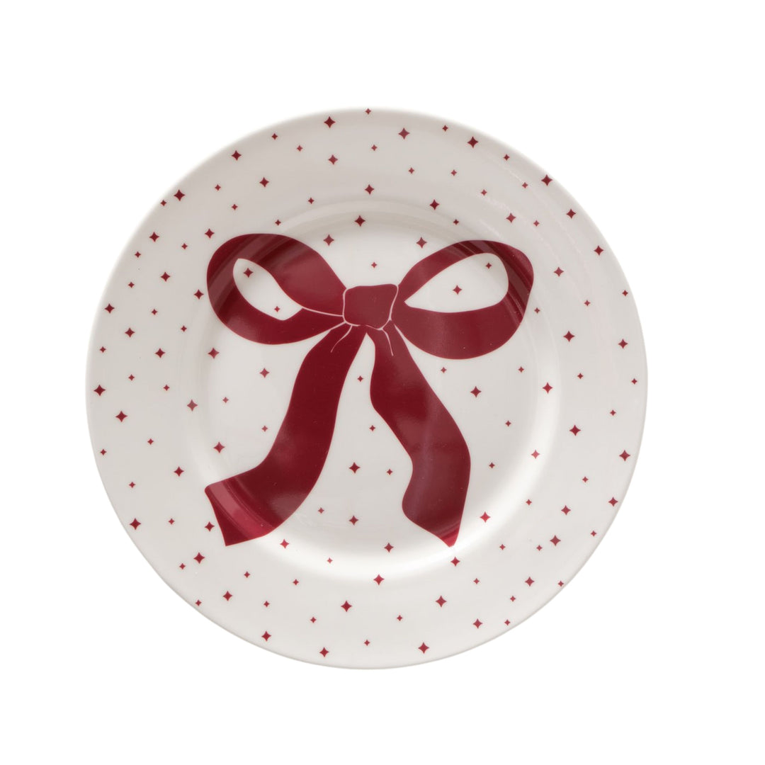Round white ceramic plate with red bow and dotted motif from LNH Edit.