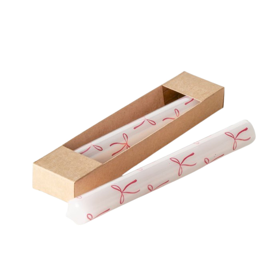 Set of two white taper candles with red bow design in kraft gift box from LNH Edit.
