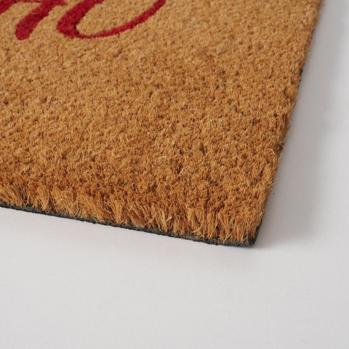 Festive coir doormat in natural and red tones.