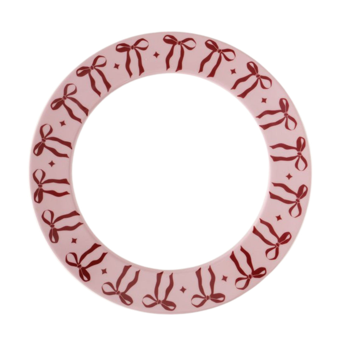 Large ceramic plate with light pink rim and red bow pattern from LNH Edit.