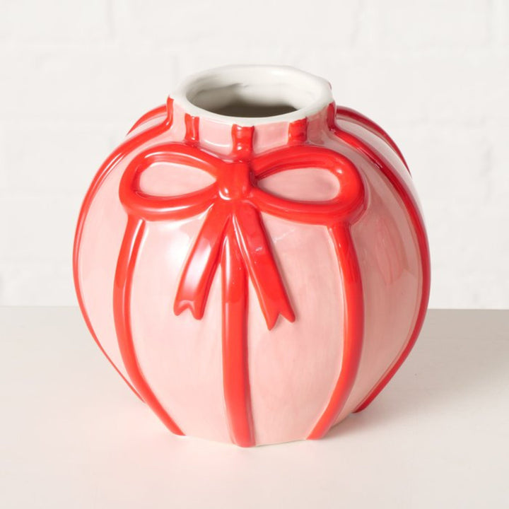 Close-up of embossed red bow detail on glossy pink Volta vase.