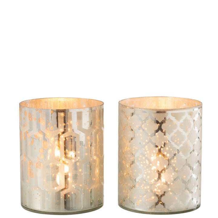 Pair of silver glass candle holders glowing with warm candlelight.