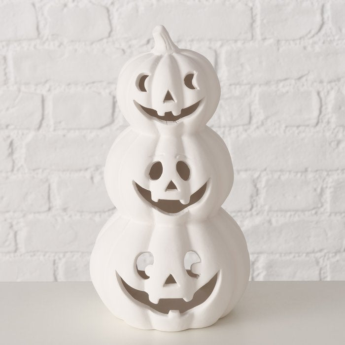 Stacked pumpkin ceramic tealight holder, 25cm tall Halloween candle decoration casting spooky flickering shadows.